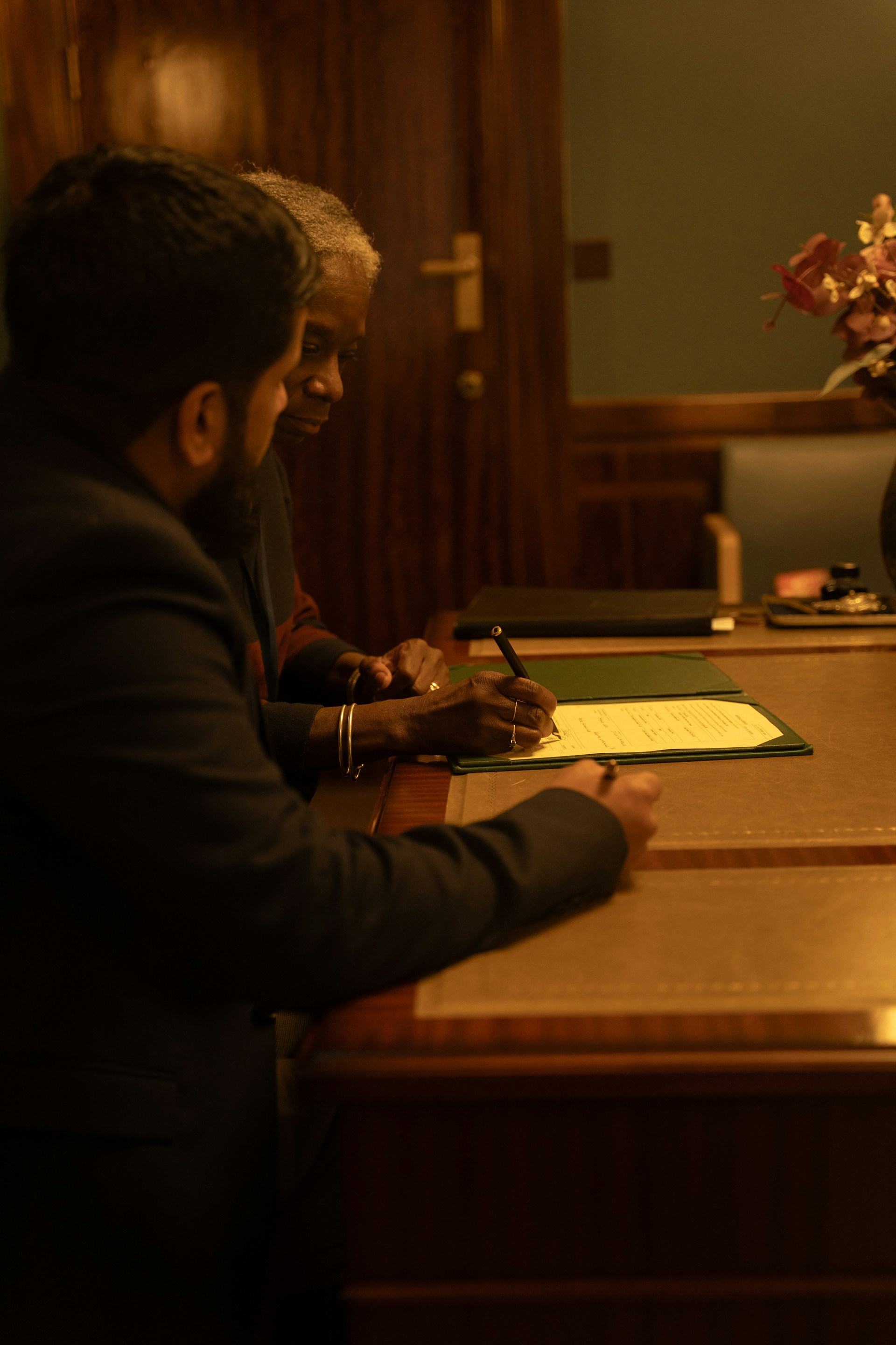 Two attorneys reviewing and signing a transactional matter file together